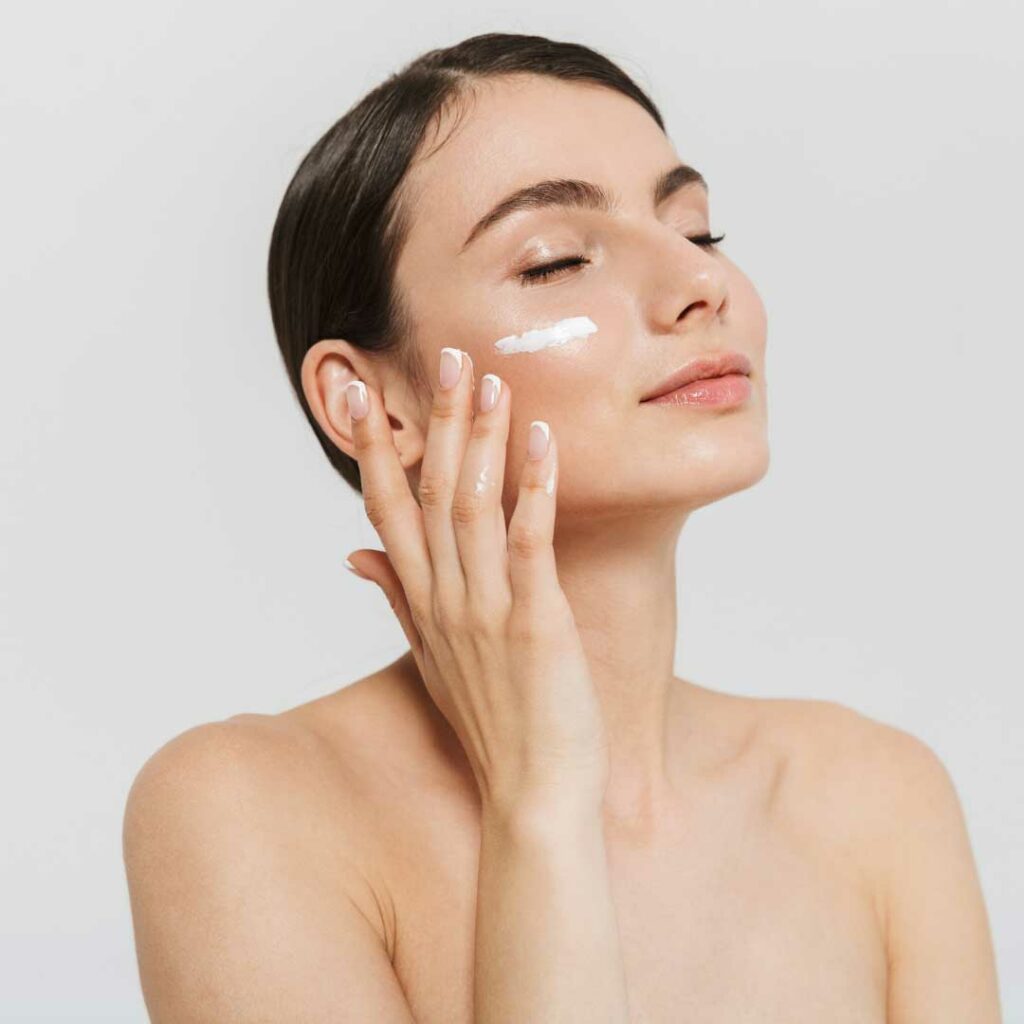 a woman applying Alpha Hydroxy Acid to her skin.